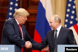 FILE - U.S. President Donald Trump and Russian President Vladimir Putin shake hands as they hold a joint news conference after their meeting in Helsinki, July 16, 2018.