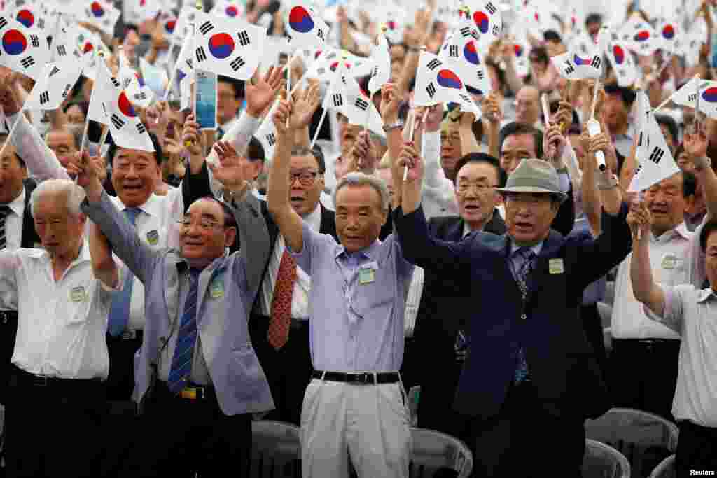 서울 용산구 국립중앙박물관에서 열린 제73주년 광복절 경축식에서 참석자들이 태극기를 흔들고 있다.