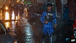 A Maldivian policeman charges with a baton towards protesters after the government declared a state of emergency, in Male, Maldives, Feb. 6, 2018. 