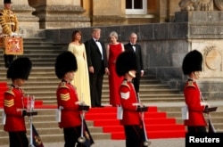 Ibu negara AS, Melania Trump, Presiden AS Donald Trump, Perdana Menteri Inggris Theresa May dan suaminya Philip May, dalam upacara penyambutan kedatangan tamu negara di Blenheim Palace dekat Woodstock, Oxfordshire, Kamis, 12 Juli 2018.