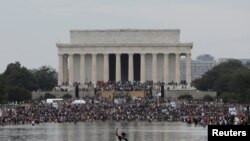 A demonstrator pumps his fist as others gather in front of the Lincoln Memorial for the "Get Your Knee Off Our Necks" march in support of racial justice that is expected to gather protestors from all over the country in Washington, U.S., August 28, 2020. 