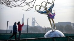 Pengunjung mengambil foto patung figure skater dengan cincin Olimpiade di sebuah taman dekat markas besar Komite Penyelenggara Olimpiade Beijing (BOCOG) di Beijing, Kamis, 18 November 2021.
