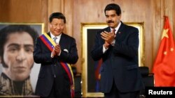 ປະທານປະເທດຈີນ ທ່ານ Xi Jinping (ຊ້າຍ) ແລະ ປະທານາທິບໍດີເວເນຊູເອລາ ທ່ານ Nicolas Maduro ພ້ອມກັນຕົບມືຊົມເຊີຍ ໃນກອງປະຊຸມທີ່ທຳນຽບ Miraflores ຢູ່ນະຄອນຫລວງ Caracas ເມື່ອວັນທີ 20 ກໍລະກົດ 2014. 