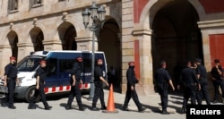 Mossos d'Esquadra, Catalan regional police officers, walk in a line outside the Catalonian regional parliament in Barcelona, Spain, Oct. 10, 2017.