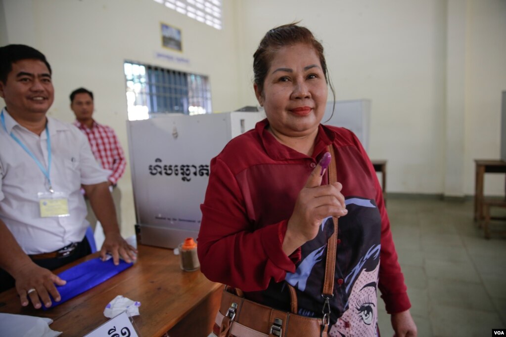 មន្ត្រីក្រុមប្រឹក្សាសង្កាត់មួយរូបបង្ហាញទឹកដៃជ្រលក់ថ្នាំបន្ទាប់ពីបានបោះឆ្នោតជ្រើសរើសព្រឹទ្ធសភា ក្នុងការិយាល័យបោះឆ្នោតមួយកន្លែងនៅក្រុងភ្នំពេញ កាលពីថ្ងៃទី២៥ ខែកុម្ភៈ ឆ្នាំ២០១៨។ (អូន ឆេងប៉រ/VOA)