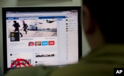 FILE - An Israeli soldier looks at the Facebook page of the IDF, at the IDF spokesperson office in Jerusalem, Nov. 15, 2012.
