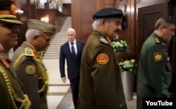 FILE - Yevgeny Prigozhin, background center, is seen at a meeting between Russian and Libyan military officials in Moscow, in a screengrab from footage published Nov. 7, 2018, by the self-styled Libyan National Army.