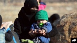 A Syrian woman and a child, evacuated from the city of Aleppo arrive at a refugee camp in Rashidin, near Idlib, Syria, Dec. 19, 2016. A plan, so far opposed by Damascus, envisions the creation of civilian safe zones in northern parts of Syria.