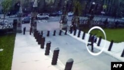 A close circuit video image shown during an Oct. 23, 2014 press conference at Royal Canadian Mounted Police headquarters in Ottawa shows suspected shooter Michael Zehaf-Bibeau (circled) running towards Parliament.
