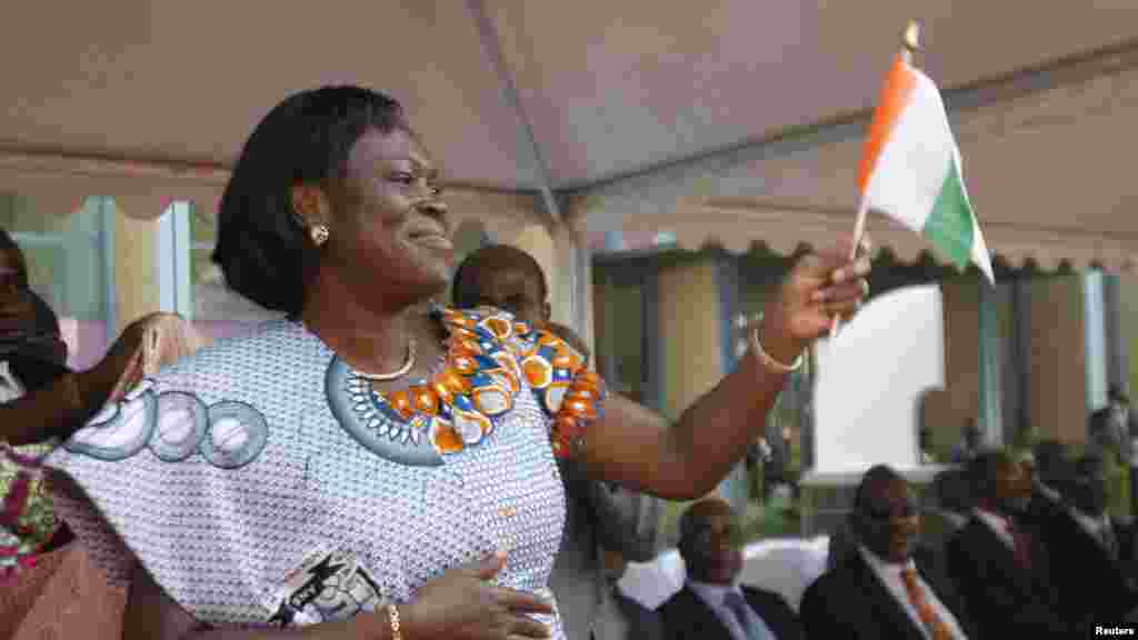 Simone Gbagbo, l&#39;épouse du président Laurent Gbagbo de Côte-d&#39;Ivoire, agite un drapelet, saluant la foule au cours de la cérémonie d&#39;ouverture des célébrations marquant le 50e anniversaire de l&rsquo;indépendance du pays, au palais présidentiel, à Abidjan, 31 janvier 2010.
