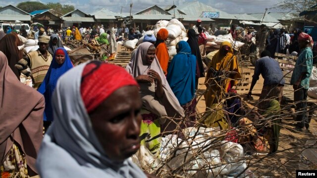 FILE - Somali refugees organize their collected ration of food during a distribution exercise outside a United Nations World Food Program center at a refugee settlement in Dadaab, Kenya, October 2013.