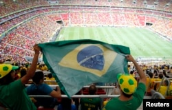 Fans hold a Brazilian flag before the Confederations Cup Group A soccer match between Brazil and Japan, June 15, 2013.
