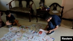 Gabriel Moncada looks at his drawings on the floor at his home in Caracas, Venezuela October 15, 2018. Picture taken October 15, 2018