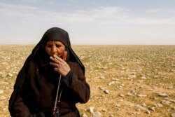 Zahra Buheir, a truffle hunter, smokes a cigarette in the desert in Samawa, Iraq, March 16, 2021. (Reuters Photo/Alaa Al-Marjani)