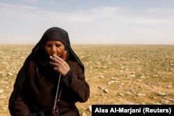 Zahra Buheir, a truffle hunter, smokes a cigarette in the desert in Samawa, Iraq, March 16, 2021. (Reuters Photo/Alaa Al-Marjani)