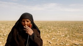 Zahra Buheir, a truffle hunter, smokes a cigarette in the desert in Samawa, Iraq, March 16, 2021. (Reuters Photo/Alaa Al-Marjani)