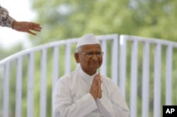 Veteran Indian social activist Anna Hazare clasps his hands together as he greets supporters after arriving for his hunger strike at Rajghat in New Delhi, June 8, 2011