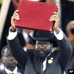 South Sudan's President Salva Kiir displays the transitional constitution of the Republic of South Sudan after signing it into law during the Independence Day celebrations in the capital Juba, July 9, 2011