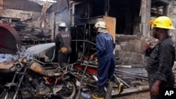 Petuga pemadam kebakaran berusaha memadamkan sisa-sisa api di lokasi pompa bensin yang meledak di Accra, Ghana Kamis (4/6).
