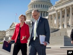 FILE - Senator Elizabeth Warren, D-Mass., left, and Senate Minority Leader Chuck Schumer, D-N.Y., walk to a news conference at the Capitol in Washington, Wednesday, Oct. 18, 2017.