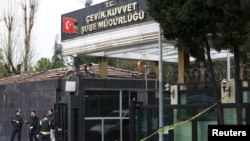 Police officers stand guard outside the damaged entrance to a police station following an attack, in the Istandbul suburb of Bayrampasa, Turkey, March 3, 2016.