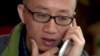 FILE - Chinese dissident Hu Jia talks on his phone during a meeting at a restaurant in Beijing, April 10, 2013.