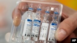 A medical worker shows vials with Russia's Sputnik V Coronavirus vaccine in a medical room, at a vaccination center in the GUM, State Department store, in Red Square in Moscow, Russia