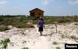 FILE - Nhorn Saroen walks to his new home in Botum Sakor National Park in Koh Kong province February 20, 2012. Nhorn Saroen, 52, is among hundreds of families who have been moved inland, after signing away their property, from a fishing village.