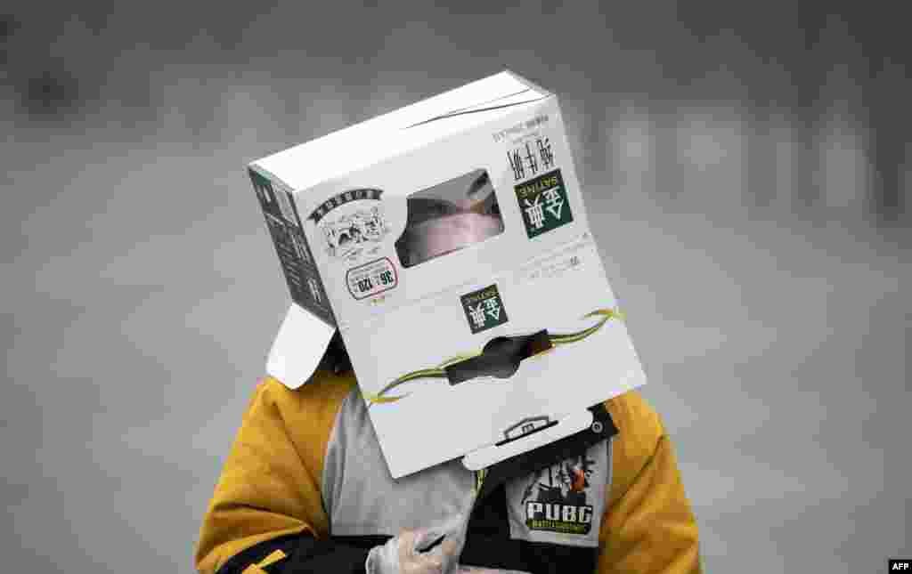 A boy wears a cardboard box on his head at the Shanghai Railway station in Shanghai, China.