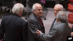 FILE - Palestinian U.N. representative Riyad Mansour, center, greets fellow diplomats before a meeting of the U.N. Security Council in New York, July 28, 2014.