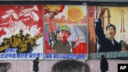Poster-poster dengan slogan-slogan kebijakan utama Korea Utara di Pyongyang.