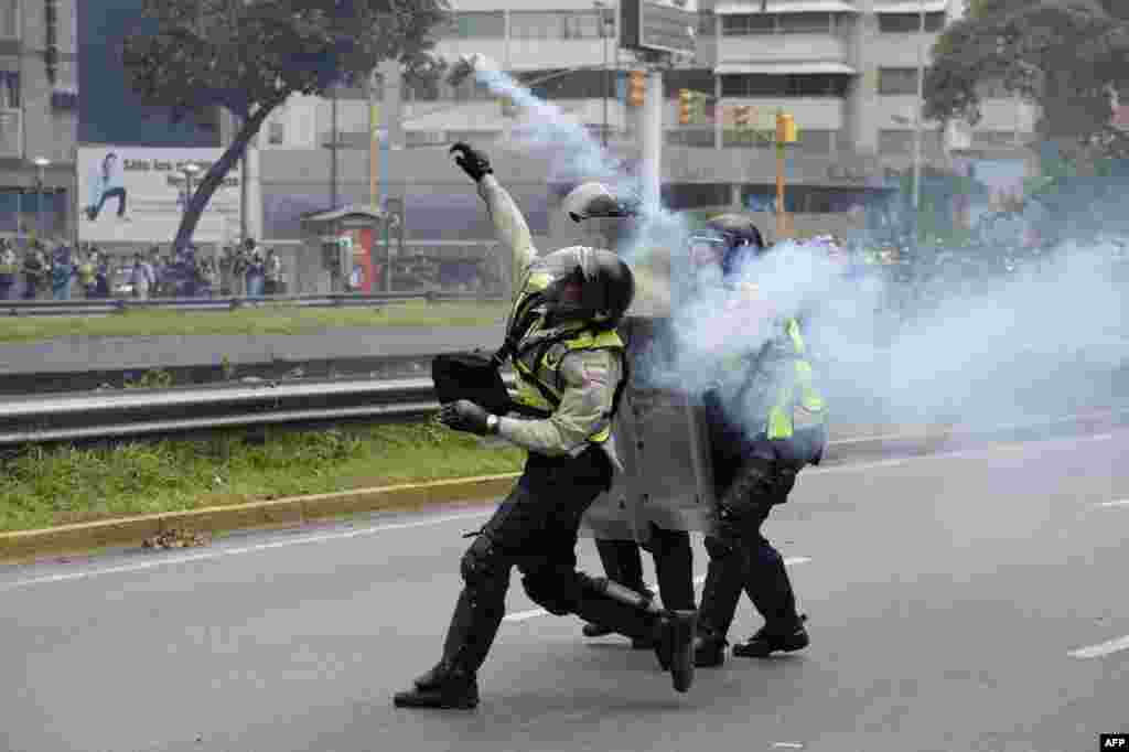 Policemen clash with demonstrators protesting against new emergency powers decreed this week by President Nicolas Maduro in Caracas, Venezuela.