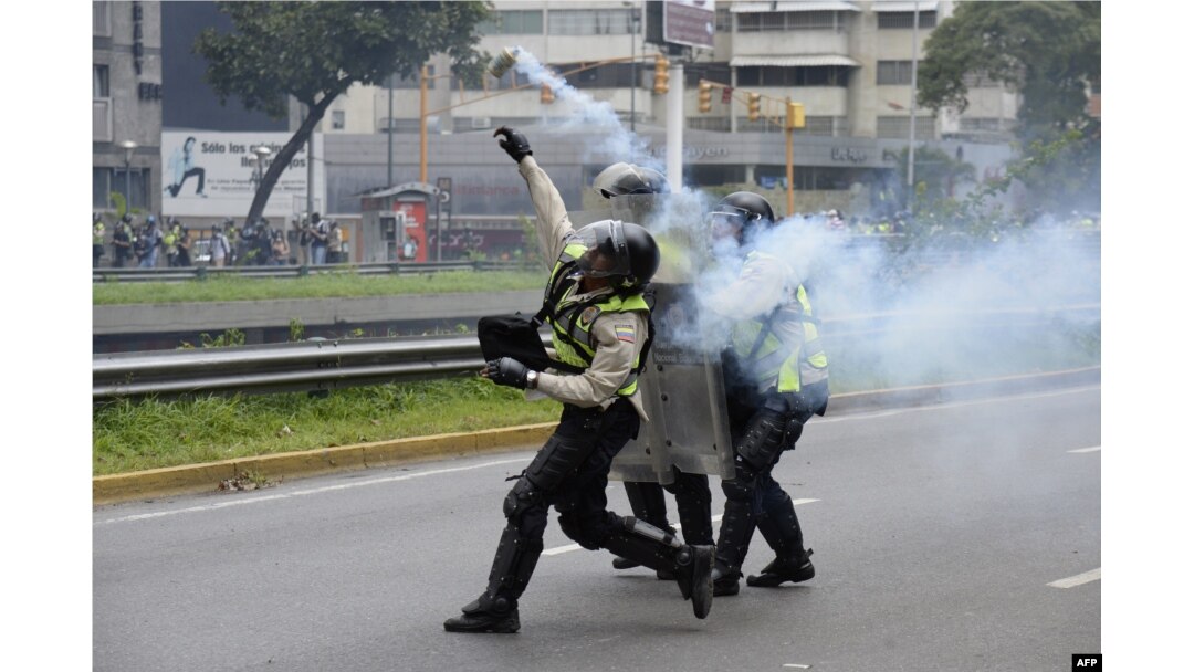Policemen clash with demonstrators protesting against new emergency powers decreed this week by President Nicolas Maduro in Caracas on May 18, 2016.