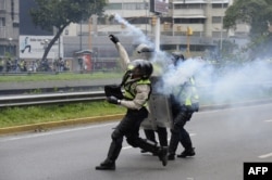 Policemen clash with demonstrators protesting against new emergency powers decreed this week by President Nicolas Maduro in Caracas on May 18, 2016.