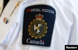 FILE - A Canada Border Services Agency logo is seen on a worker during a tour of the Infield Terminal at Toronto Pearson International Airport in Canada on Dec. 8, 2015.