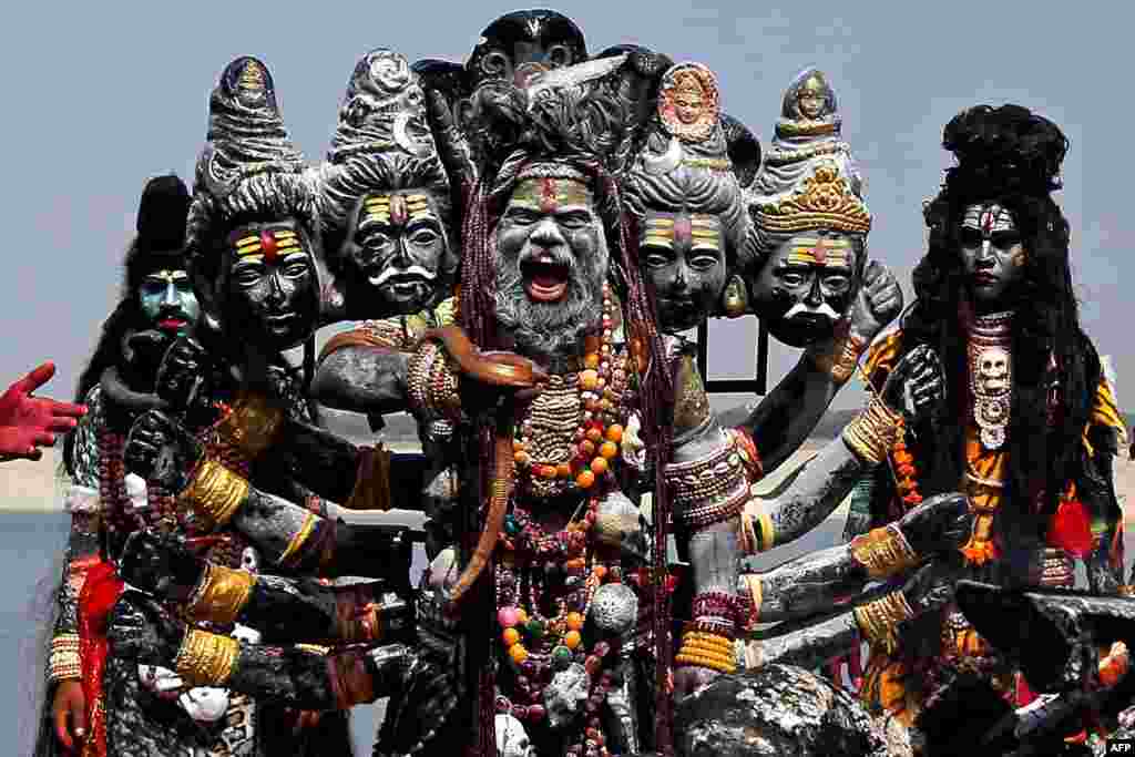 People dressed as Hindu gods prepare to march in a religious service along the banks of the Ganges river in Varanasi, India.