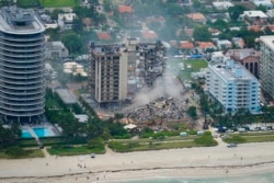 In this Friday, June 25, 2021, file photo, rescue personnel work in the rubble at the Champlain Towers South Condo, in Surfside, Fla. (AP Photo/Gerald Herbert, File)