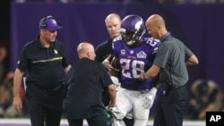 Minnesota Vikings running back Adrian Peterson (28) is helped off the field after getting injured during an NFL football game against the Green Bay Packers, Sept. 18, 2016.