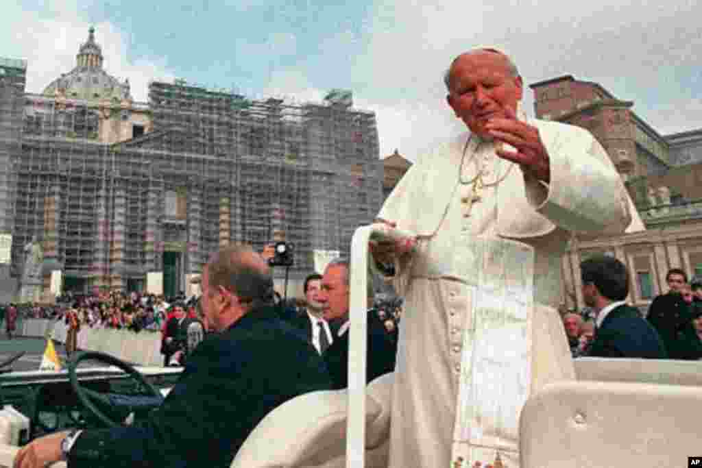 Pope John Paul II gestures from his vehicle as he tours St. Peter's Square during the weekly general open-air audience at the Vatican, April 1, 1998 (AP)