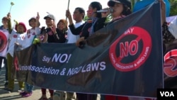 Cambodian human rights and land activists holding a banner that reads "Say NO! Union, Association & NGO Laws" during a protest in front of the National Assembly, in Phnom Penh, June 28, 2015. (Hul Reaksmey/VOA Khmer)