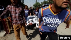 Rescue workers move a body after an attack on the Chinese consulate, where blasts and shots were heard, in Karachi, Pakistan, Nov. 23, 2018.