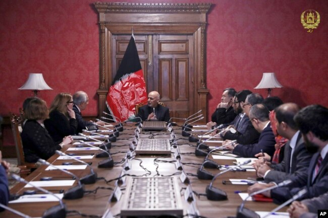 FILE - In this photo released by the Afghan Presidential Palace, Afghan President Ashraf Ghani, center, speaks to U.S. peace envoy Zalmay Khalilzad, third left, at the presidential palace in Kabul, Afghanistan, Jan. 28, 2019.