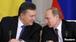 Russia's President Vladimir Putin (R) looks at his Ukrainian counterpart Viktor Yanukovich during a signing ceremony after a meeting of the Russian-Ukrainian Interstate Commission at the Kremlin in Moscow, Dec. 17, 2013.