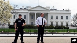 Members of the Secret Service stand outside the White House, April 7, 2015.