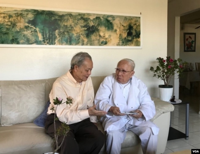 Ông Huỳnh Văn Lang (bên phải), với DVD Bách Khoa trên tay, đang trò chuyện với Phạm Phú Minh. (Ảnh: Trần Huy Bích)