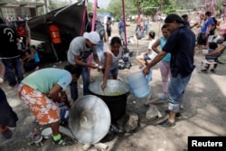 Central American migrants prepare food as they take a break from traveling in their caravan on their journey to the U.S., in Matias Romero, Oaxaca, Mexico, April 3, 2018.