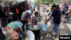 اعضای کاروان پناه‌جویان از آمریکای مرکزی به سوی مرز آمریکا، در حال آماده‌سازی غذا در اوهاکای مکزیک، سه شنبه ۳ آوریل
