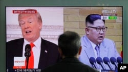 FILE - A man watches a TV screen showing file footage of U.S. President Donald Trump, left, and North Korean leader Kim Jong Un, right, during a news program at the Seoul Railway Station in Seoul, South Korea, March 27, 2018. 