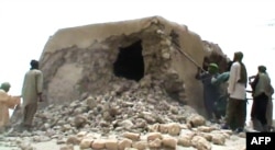 FILE - This file photo taken on July 1, 2012 shows a still from a video of Islamist militants destroying an ancient shrine in Timbuktu.