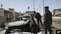 An Iraqi policeman stands guard at the site of a bomb attack in Ramadi, 100 km (60 miles) west of Baghdad, March 20, 2012. 